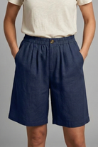 Womens linen shorts featuring an elastic waist and side pockets, designed for a relaxed fit perfect for warm weather. 7