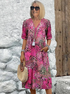 Womens summer dress featuring a V-neck design and a vibrant floral pattern, knee-length, made from soft fabric, and includes convenient side pockets. 2
