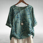 Womens soft blue linen-look short sleeve blouse featuring a relaxed fit and vibrant floral print, perfect for casual summer outings. 1
